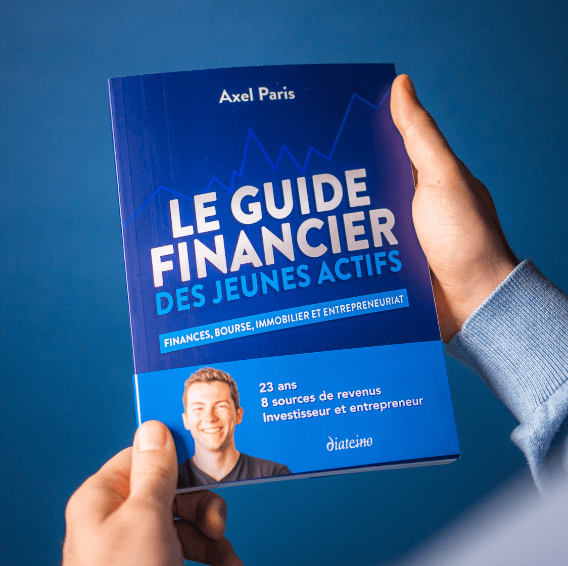 Mains tenant le Guide Financier des Jeunes Actifs